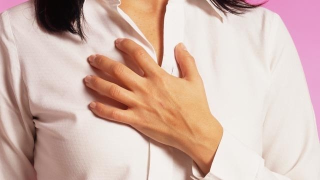 женщина держится за больную грудь