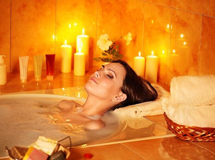 Девушка лежит в ванее при
свечах