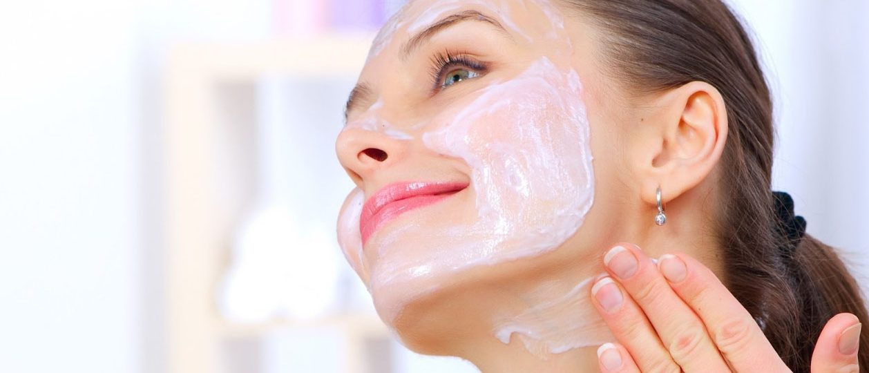 Девушка мажет лицо кремом