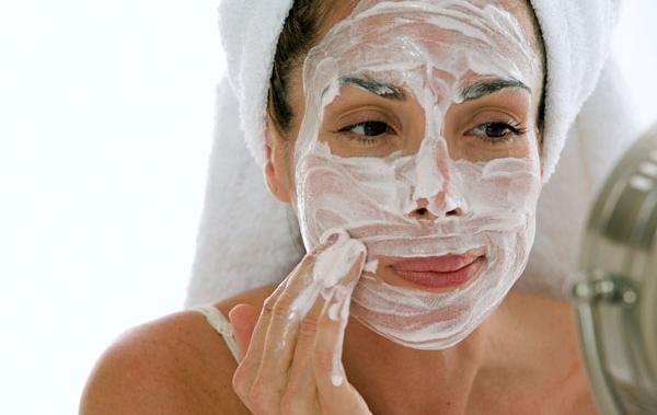 Девушка наносит маску на лицо