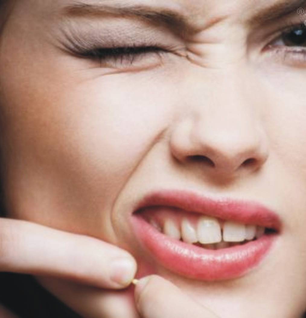 Девушка выдавливает прыщик