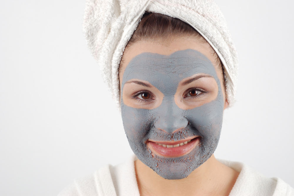 Глиняная маска на лице у девушки