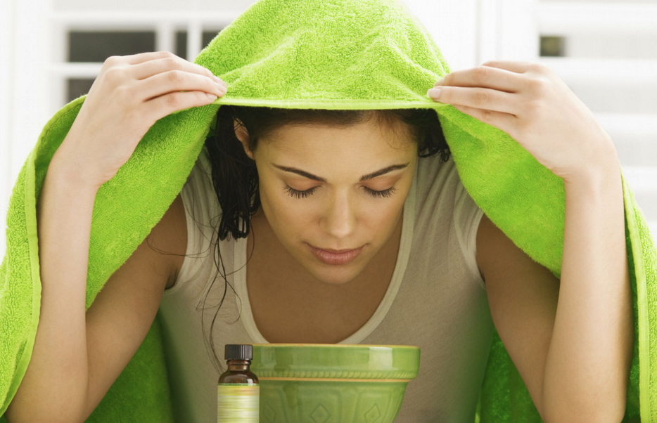 Девушка склонилась над чашей с ингаляционным раствором