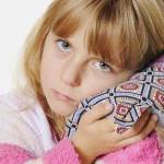 Ребёнок прикладывает солевой компресс к уху