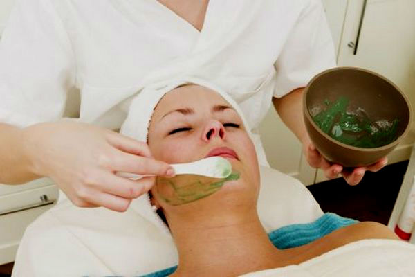 Косметолог делает девушке маску