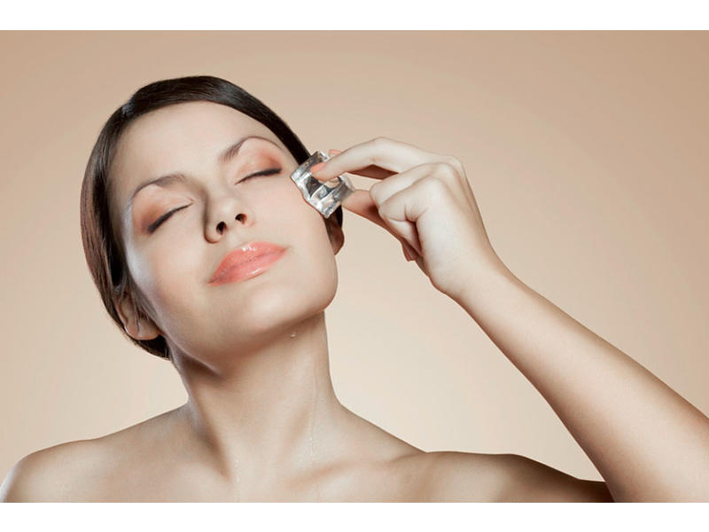 Девушка протирает лицо кубиком льда