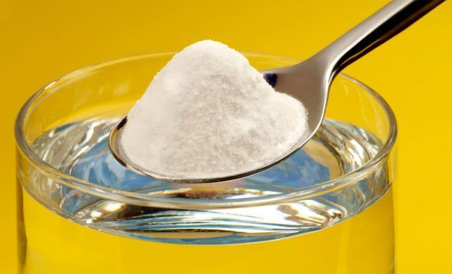 Сода в ложке и стакан воды