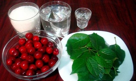 Вишня и листочки, стаканы с водкой и сахаром на столе