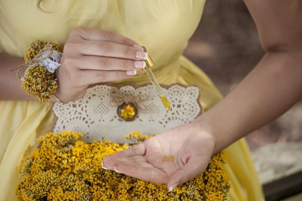 Цветы цмина и капли его масла в ладони