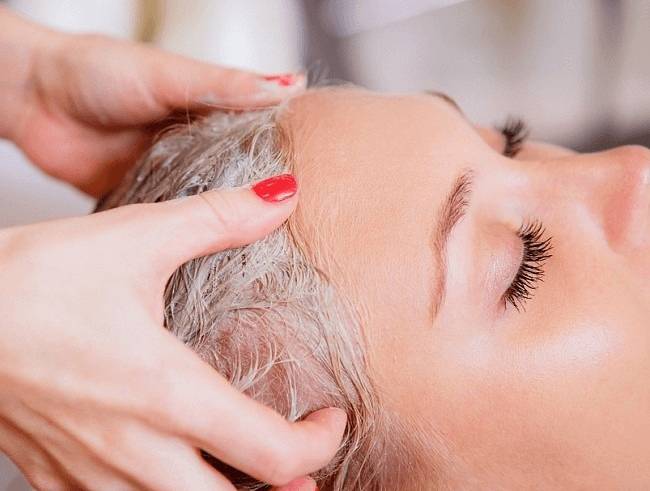 Нанесение маски женщине на волосы