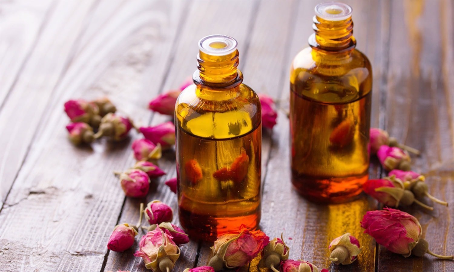 Розовые бутоны и масло во флаконах