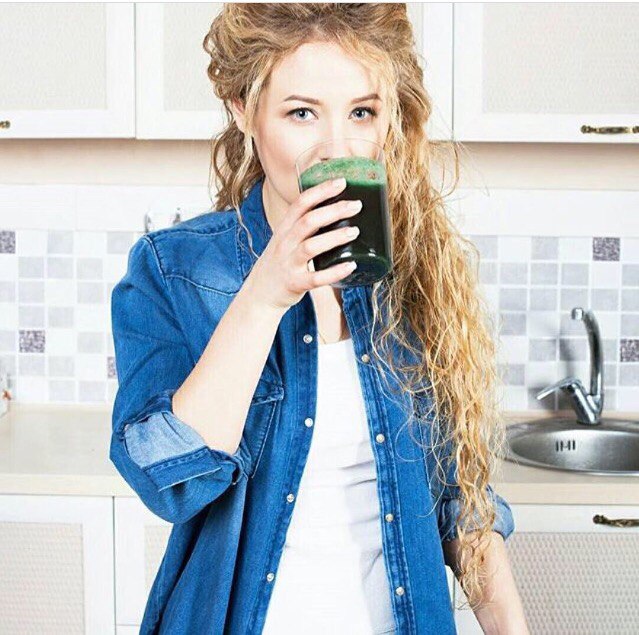 Девушка пьёт напиток из спирулины