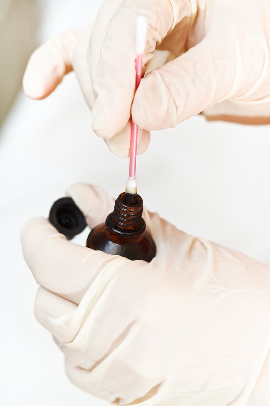 Смачивание ватной палочки в растворе йода