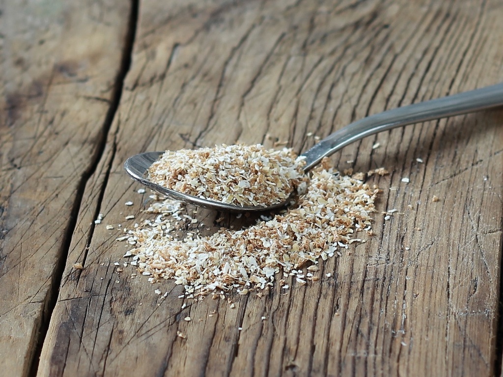 Столовая ложка с отрубями на столе