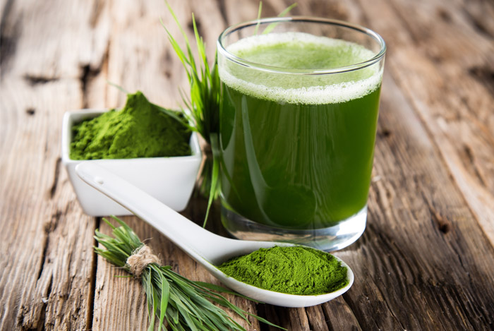 Витграсс в стакане и зелёный порошок в ложке