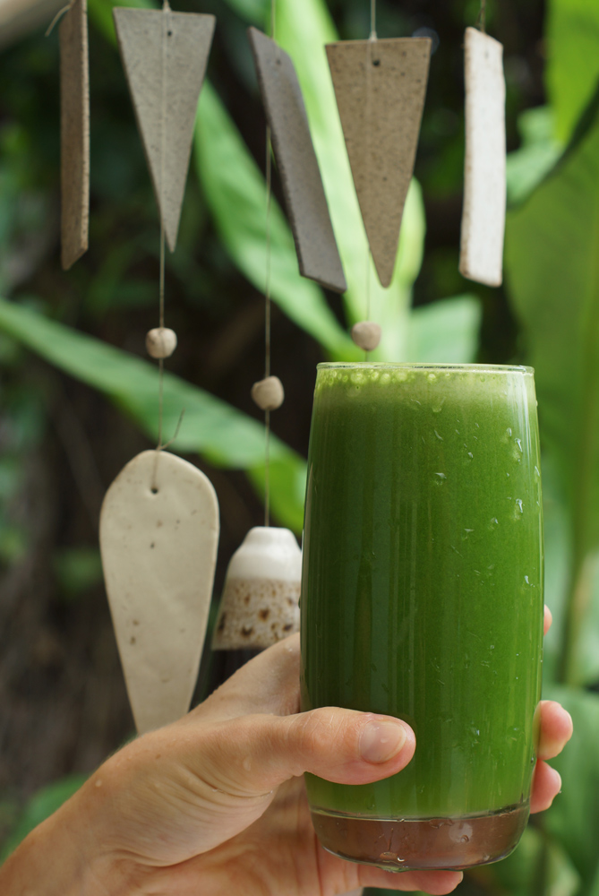 Стакан с зелёным соком в руке